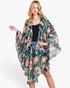 Beach Rose Co. tropical flower and leaf print shawl cover-up worn by a blonde model over a black tank top.
