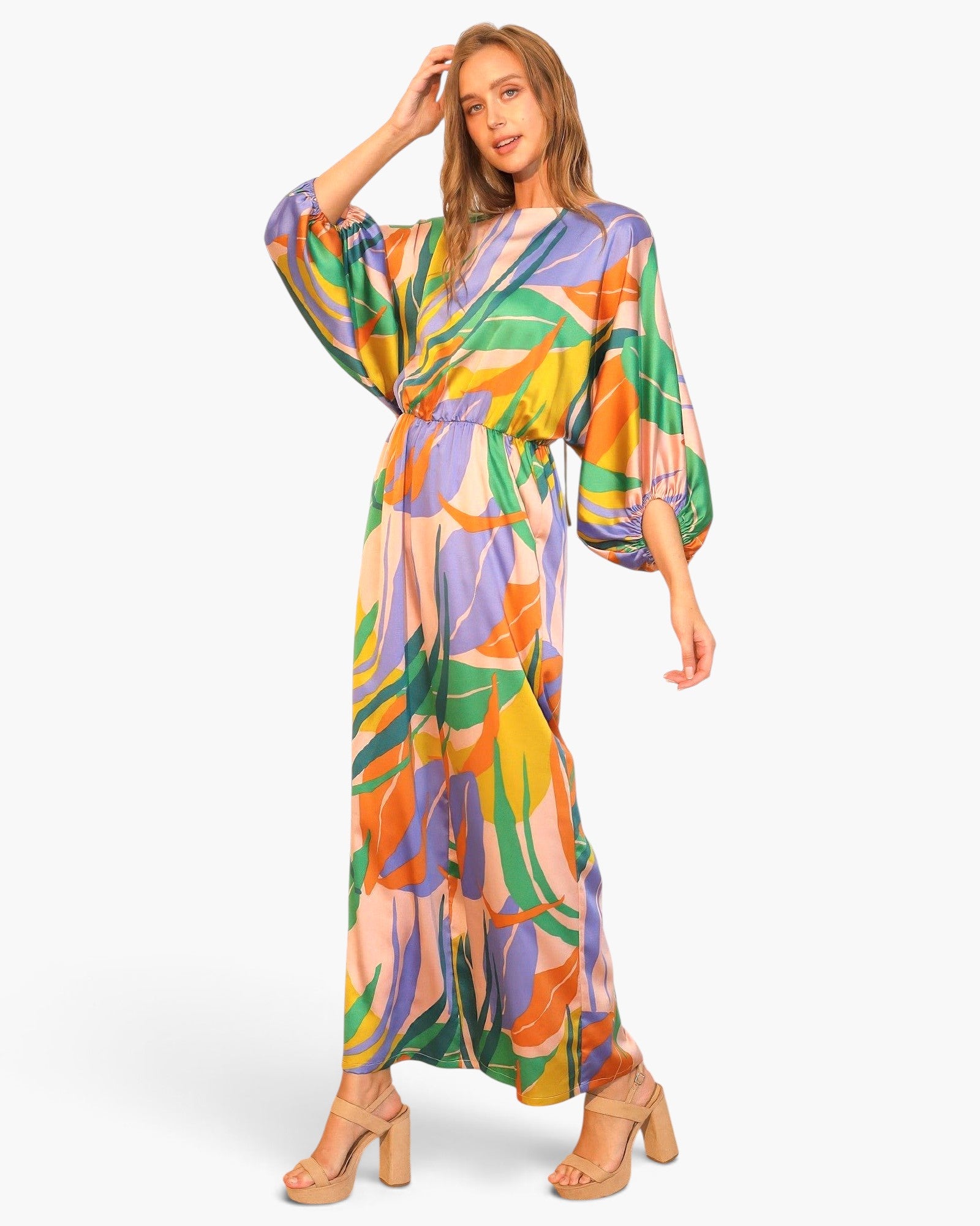 Beach Rose Co. satin jumpsuit with a vibrant tropical print, boat neckline, and blouson sleeves on a female model.