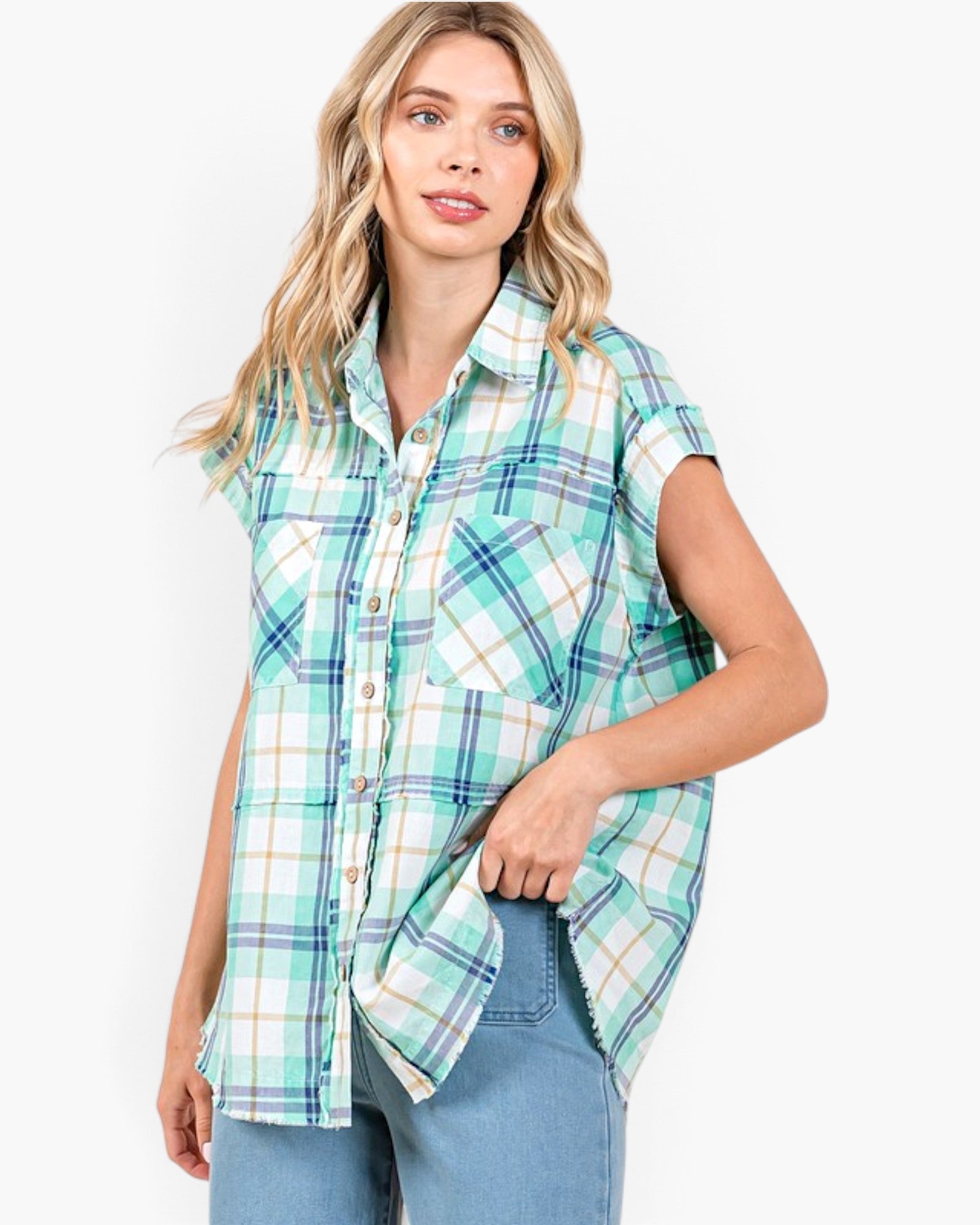 Model wearing a Beach Rose Co. turquoise plaid cotton button-front shirt with cap sleeves and raw hem detailing.