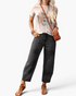 Beach Rose Co. washed black barrel leg jeans with panel detailing and cropped hem worn with a graphic tee and sandals.