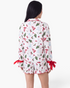 Beach Rose Co. white viscose pajama set with Christmas tree print, red bows, and ruffled shorts hem, back view.