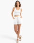 Beach Rose Co. white cotton lounge shorts with a drawstring waist worn by a model with a matching white tank top