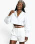 Beach Rose Co. white cropped blouse with balloon sleeves, smocked cuffs, and button front worn by a smiling model.