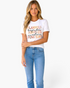 Beach Rose Co. white crew neck t-shirt with autumn-themed typography graphic in warm colors worn by a blonde model.