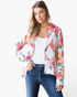 Beach Rose Co. white blazer with pink and coral floral print, notched lapels, and single-button closure on a model.
