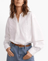 Beach Rose Co. white long-sleeve blouse with floral embroidery, split neckline, and openwork sleeve detail.