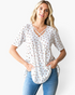 Beach Rose Co. white textured waffle knit tunic with a ditsy floral print and crisscross strap V-neckline