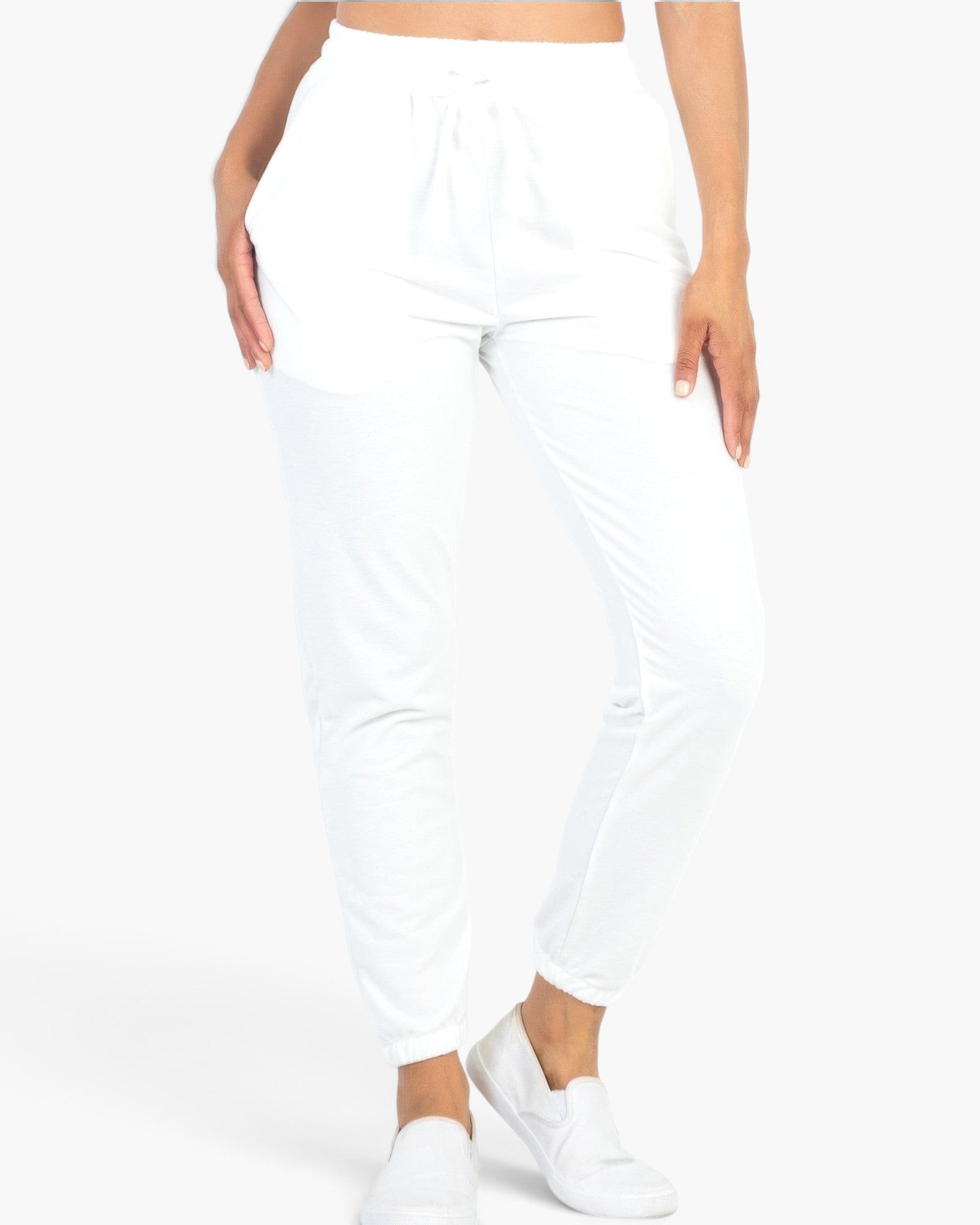 Beach Rose Co. white French Terry jogger pants with an elastic waistband and tapered cuffs on a model.