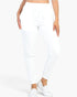 Beach Rose Co. white French Terry jogger pants with an elastic waistband and tapered cuffs on a model.