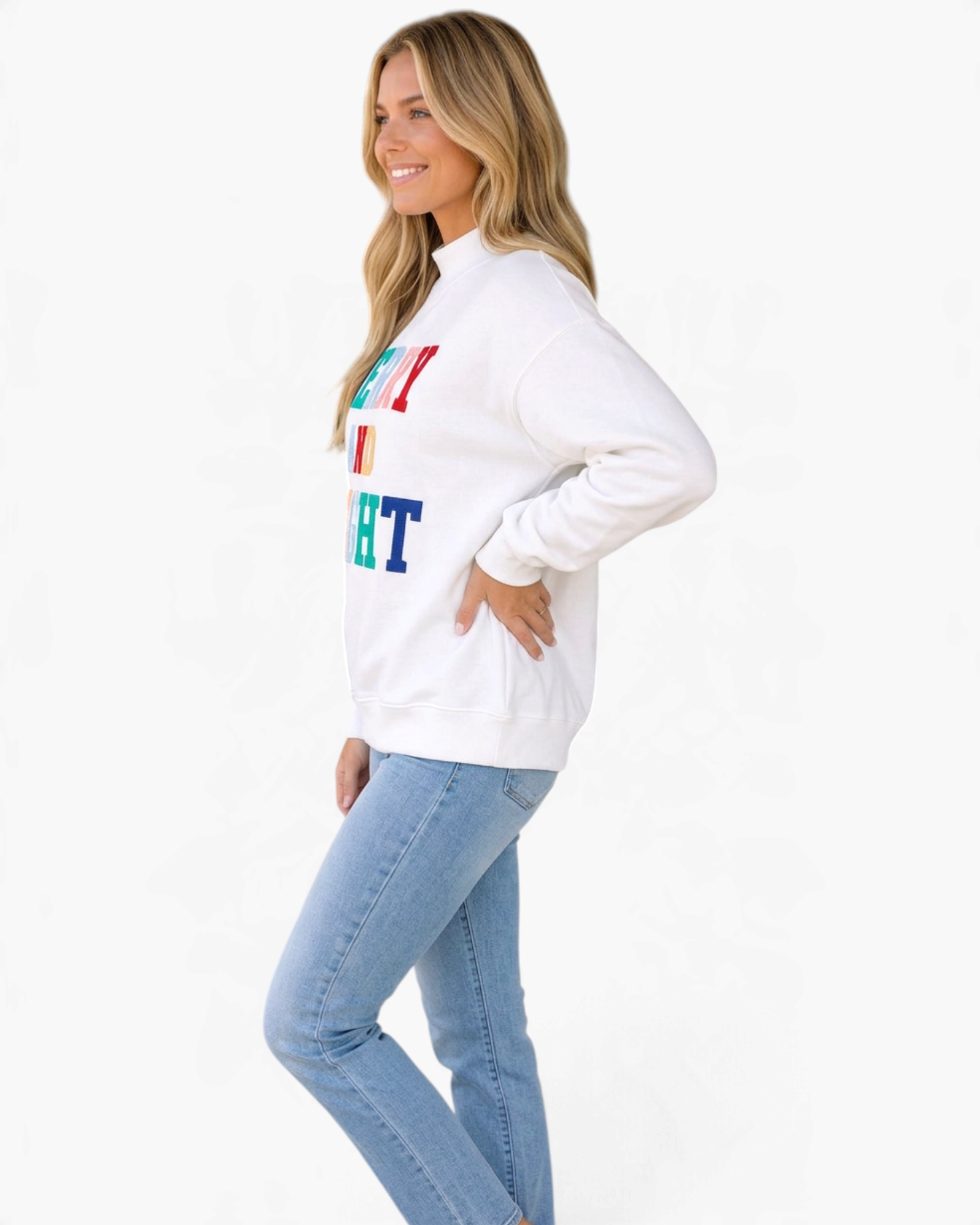 Beach Rose Co. white mock neck sweatshirt with multicolored Merry and Bright appliqué worn by a smiling blonde woman.