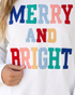 Beach Rose Co. white sweatshirt featuring multicolored MERRY AND BRIGHT appliqué lettering with stitched detailing.