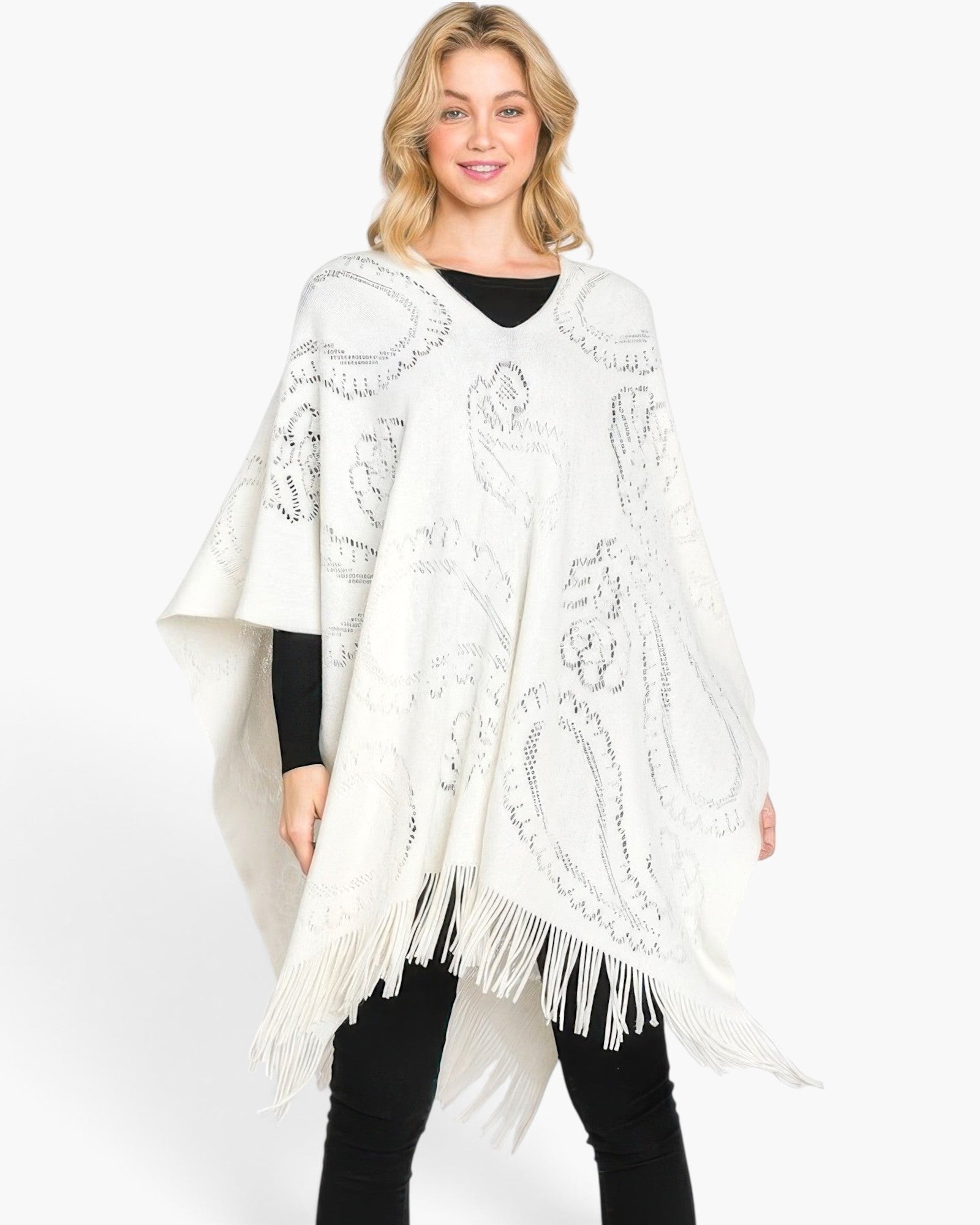 Beach Rose Co. white acrylic poncho featuring a subtle paisley pattern and fringe hem worn by a blonde model.