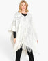 Beach Rose Co. white acrylic poncho featuring a subtle paisley pattern and fringe hem worn by a blonde model.