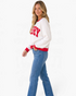 Beach Rose Co. white waffle knit crewneck sweatshirt with red MERRY lettering and trim worn by a model in jeans