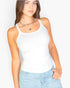 Beach Rose Co. white ribbed knit cami top worn by a woman with layered silver necklaces and light wash denim jeans.