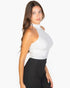 Beach Rose Co. white ribbed halter neck backless top worn by a woman with long brown hair against a white background