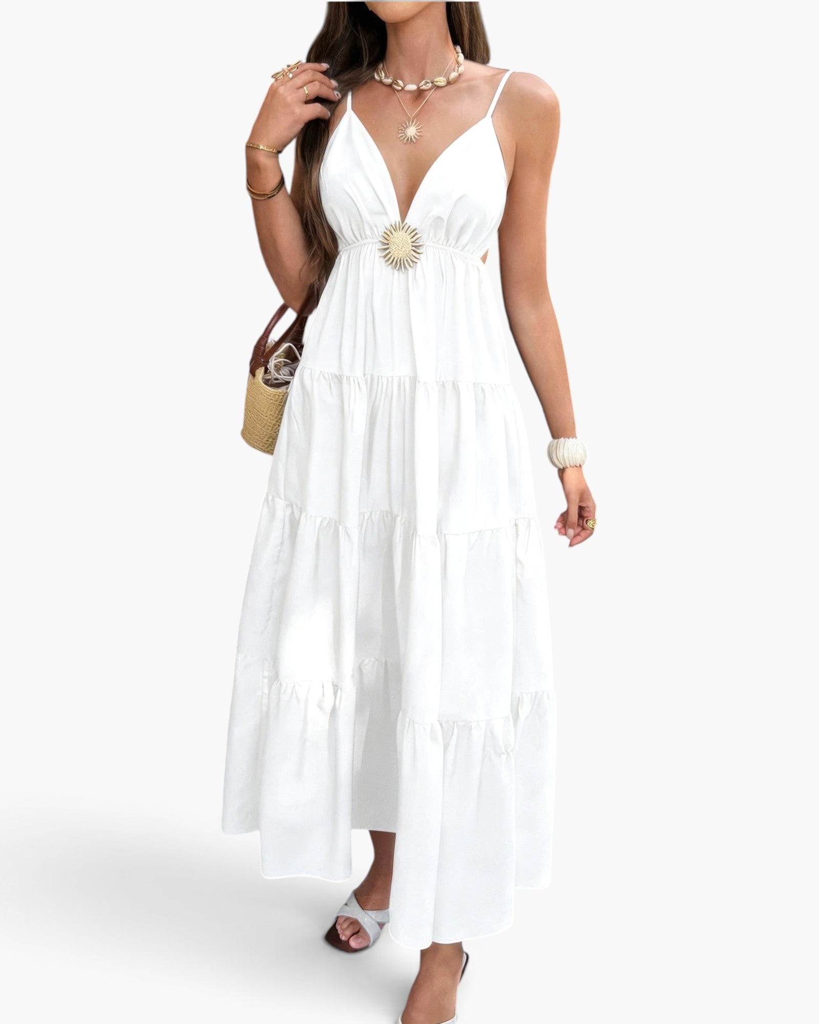 Beach Rose Co. white sleeveless maxi dress with a high waist, open back, and tiered skirt, styled with a straw bag.