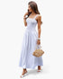 Beach Rose Co. white sleeveless A-line maxi dress with a square neckline, worn by a model with a straw handbag.