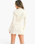 Beach Rose Co. white waffle knit two-piece set with long bell sleeves and a mini skirt, back view on a model.