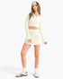 Beach Rose Co. white waffle knit two-piece set with a collared bell sleeve crop top and matching mini skirt on a model