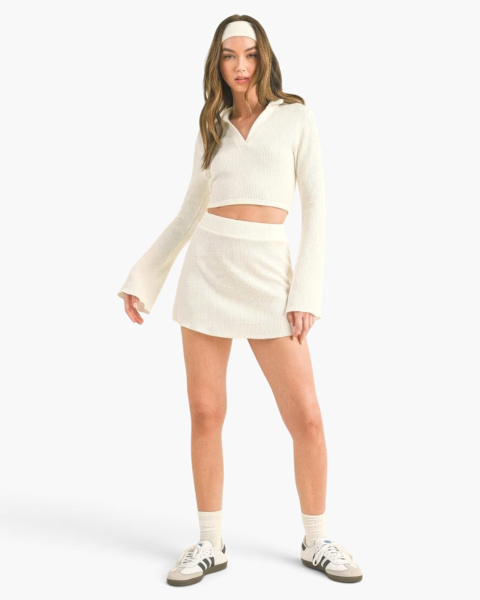 Beach Rose Co. white waffle knit two-piece set with a collared bell sleeve crop top and matching mini skirt on a model