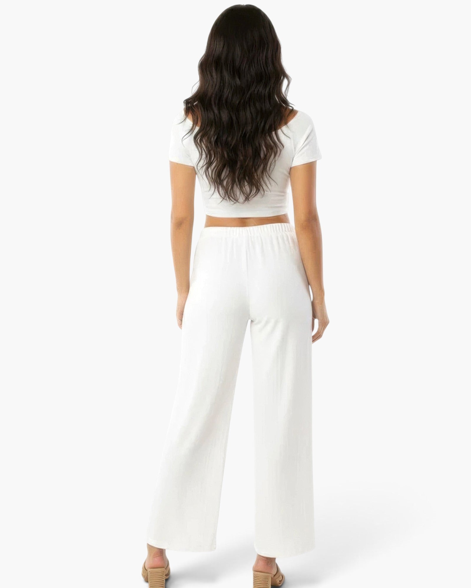 Back view of a woman wearing Beach Rose Co. white relaxed fit wide-leg cotton pants with a matching crop top.