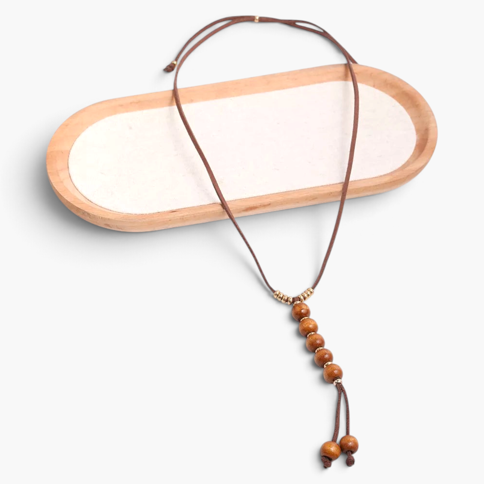 Beach Rose Co. long boho necklace with brown PU cord, wooden beads, and gold-tone accents on a wooden tray.