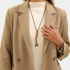 Beach Rose Co. long boho necklace featuring brown PU cord, wooden beads, and gold-tone accents on a model.