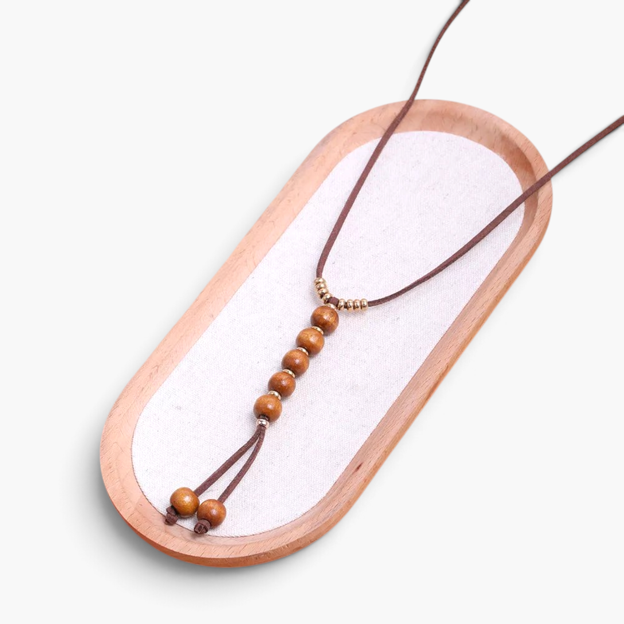 Beach Rose Co. long boho necklace featuring brown PU cord, wooden beads, and gold-tone accents on a wooden tray.