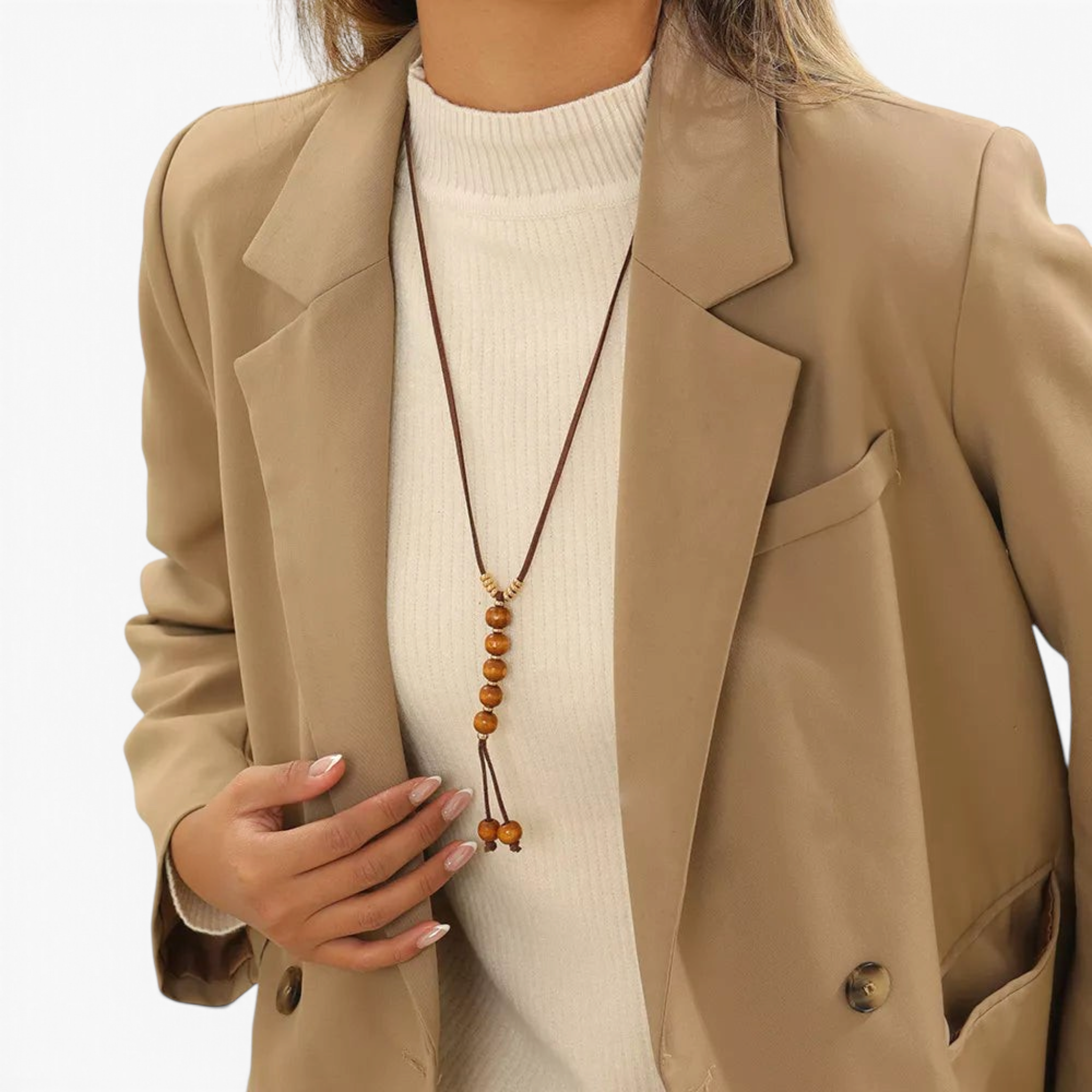 Beach Rose Co. long boho necklace with brown PU cord, wooden beads, and gold-tone accents worn over a beige blazer.