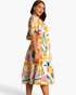 Beach Rose Co. yellow multicolor abstract print midi dress with flutter sleeves and a tiered skirt on a model