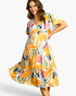Beach Rose Co. yellow multicolor abstract print midi dress with flutter sleeves and tiered ruffled skirt on a model