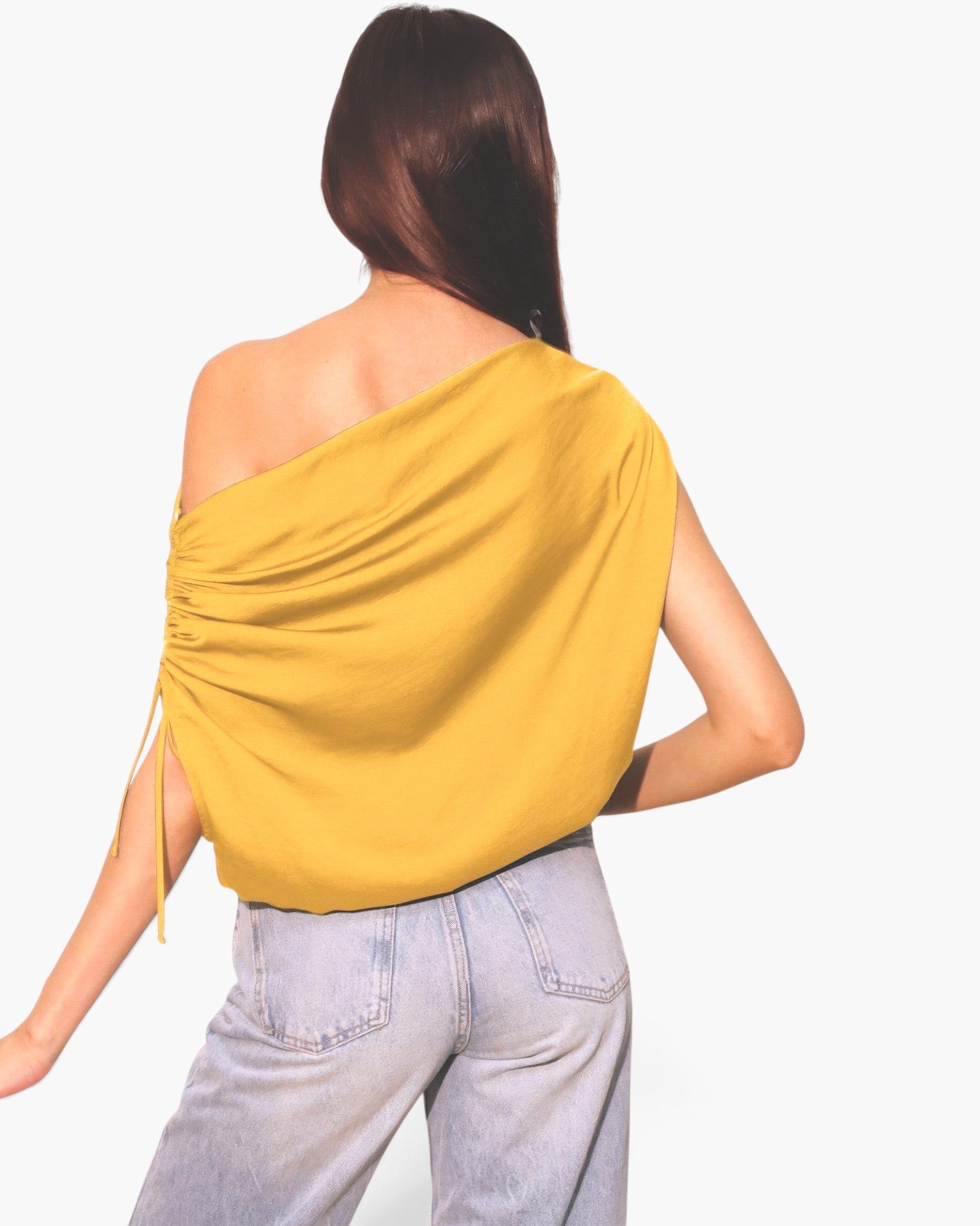 Beach Rose Co. yellow asymmetrical drawstring top in washed poly silk worn with light wash denim jeans