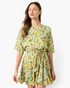Beach Rose Co. yellow floral mini dress with elbow-length sleeves and a removable braided waist tie on a model