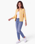 Beach Rose Co. yellow knit cardigan with pink polka dots, round neckline, and button front worn with blue jeans.