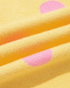 Close-up of Beach Rose Co. yellow knit fabric with pink polka dot pattern showing soft texture and folds.