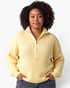 Beach Rose Co. model wearing a yellow ribbed knit half-zip sweater with a stand collar and relaxed fit.