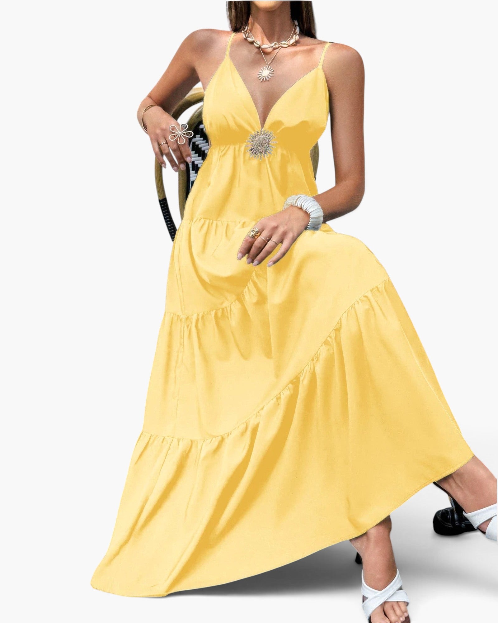 Beach Rose Co. yellow sleeveless maxi dress with a high waist, tiered skirt, and open back detail on a seated model.