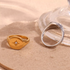 Beach Rose Co. gold-plated signet ring with a starburst engraving and clear zircon stone next to a silver band.