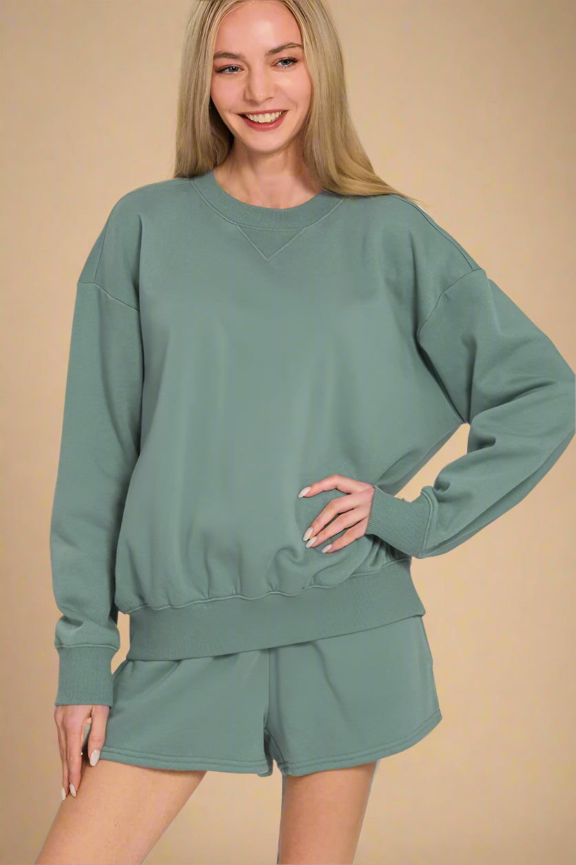 Woman wearing a green sweatshirt and shorts set on a white background