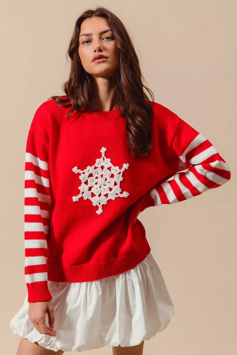 Woman wearing a red sweater with a white snowflake design on a beige background