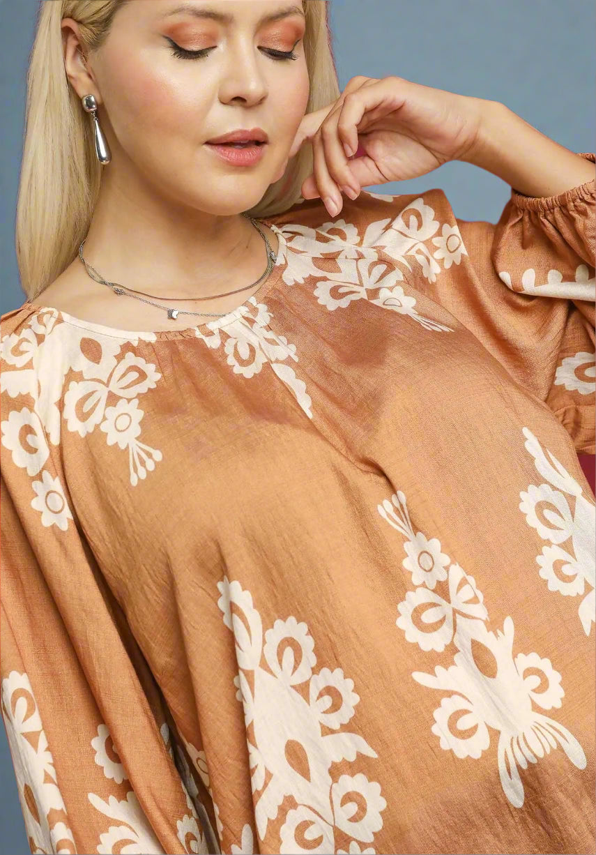Woman wearing a brown blouse with white lace details