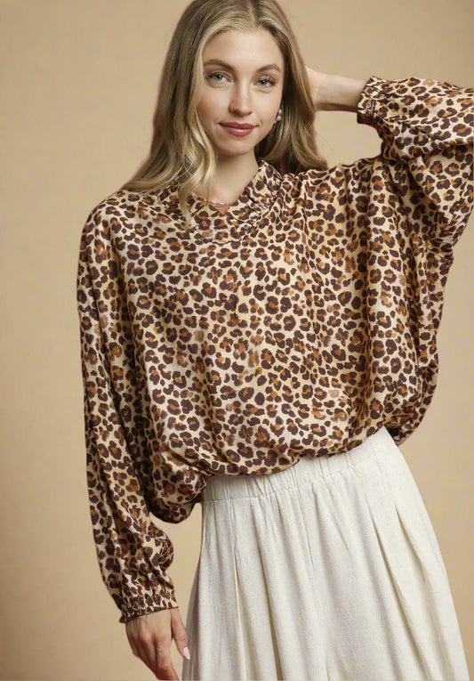 Woman wearing a leopard print blouse and white skirt against a red background