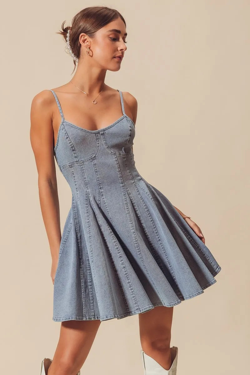 Woman wearing a denim dress against a beige background