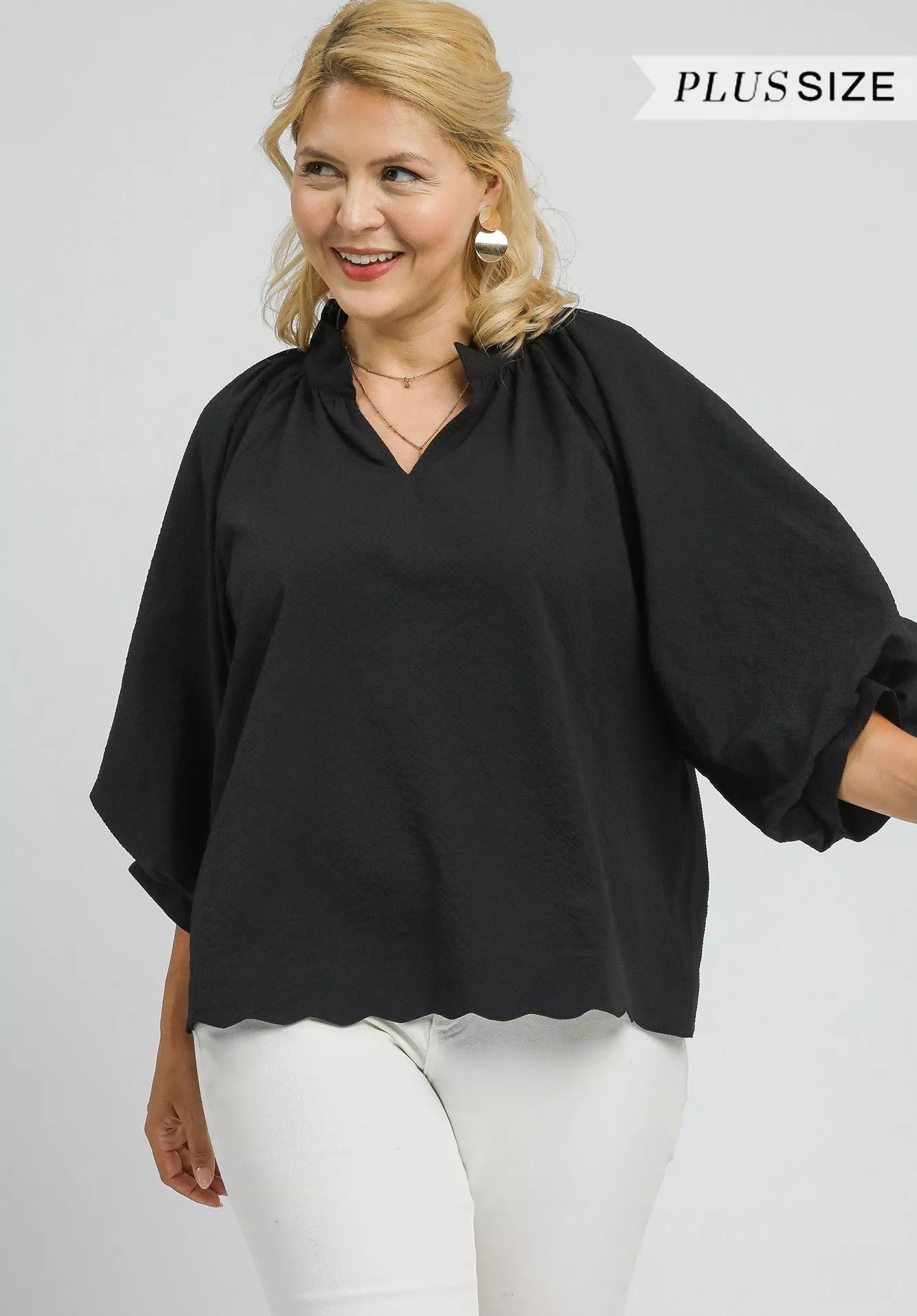 Woman wearing a black blouse with a plain background