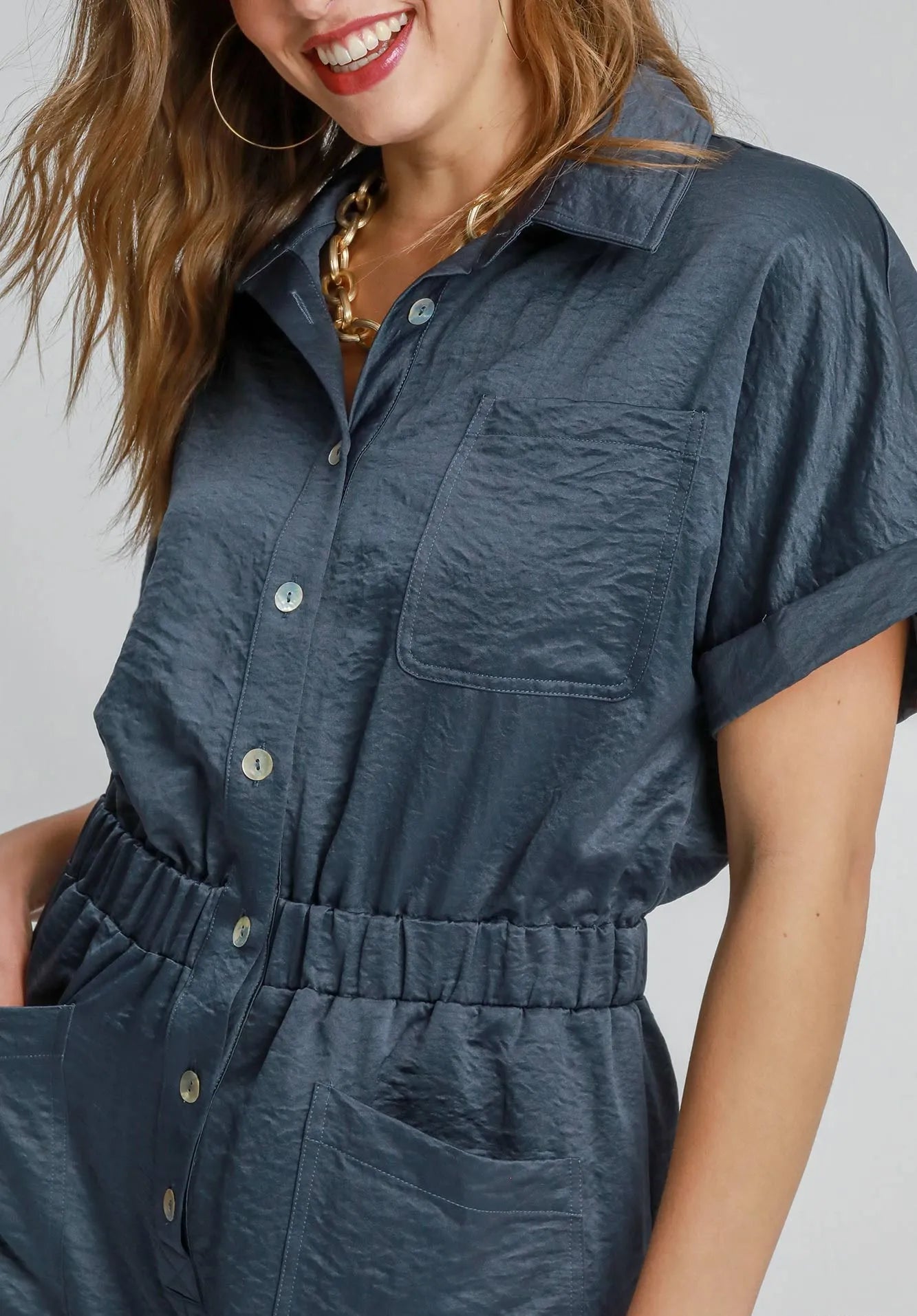 Woman wearing a navy romper with a plain background