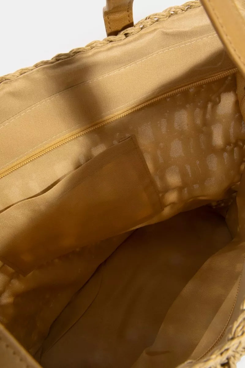 Close-up of a beige woven bag with a handle and interior.
