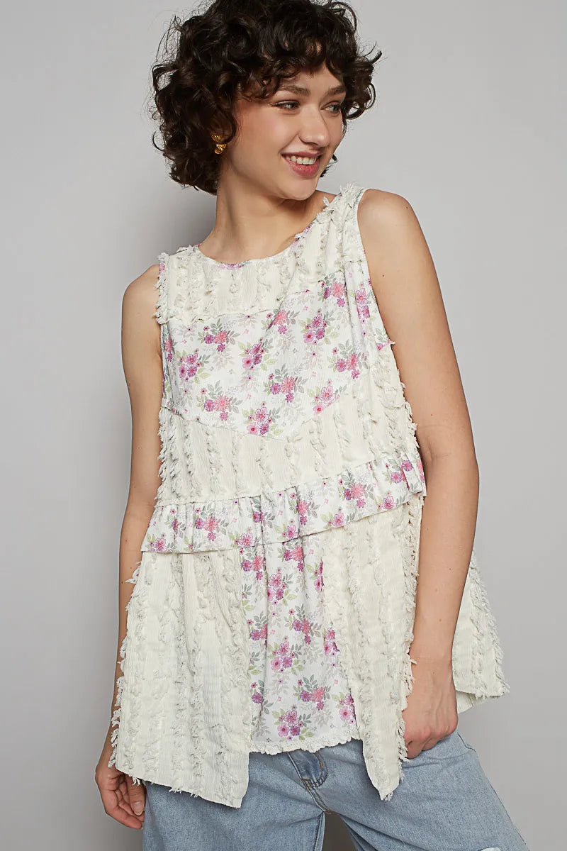 Woman wearing a floral sleeveless top against a gray background