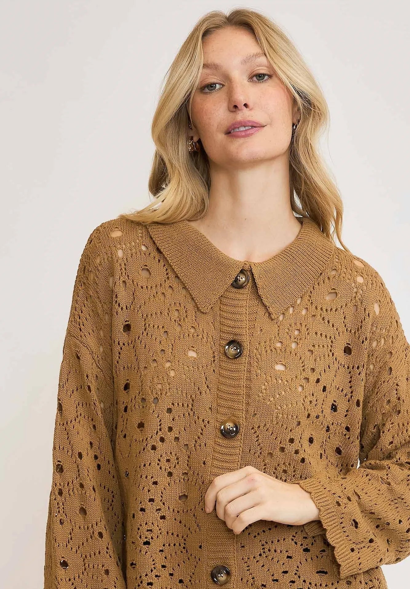 Woman wearing a brown knitted cardigan with a white background