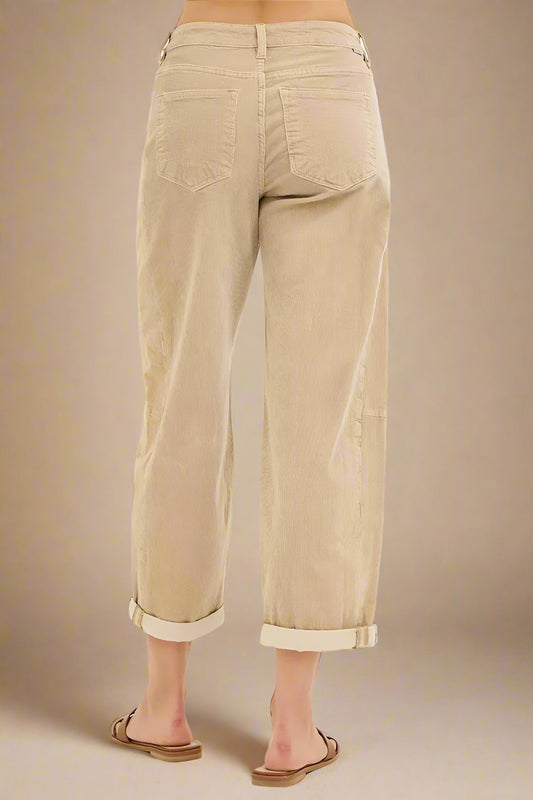 Beige pants worn by a person on a white background